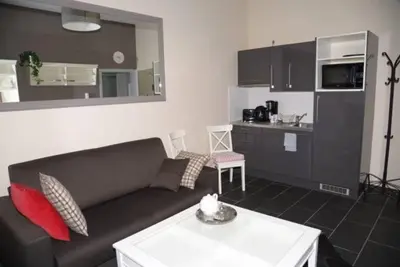 a living room with a couch and a kitchen at Appartbrussels in Brussels