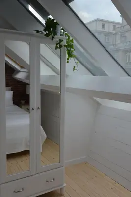 a room with a mirror and a bed in a attic at Appartbrussels in Brussels