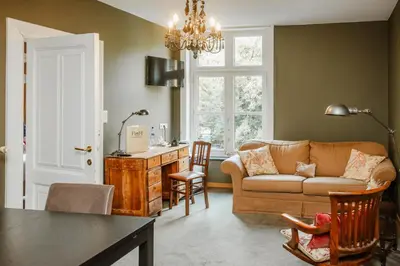 a living room with a couch and a table at Boutique hotel Roosendaelhof in Geel
