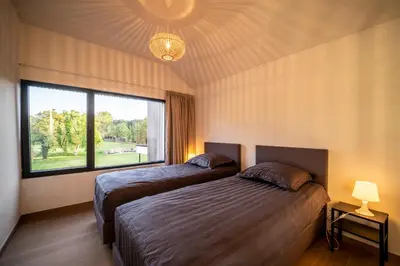 a bedroom with two beds and a large window at VELPE 55 in Bierbeek