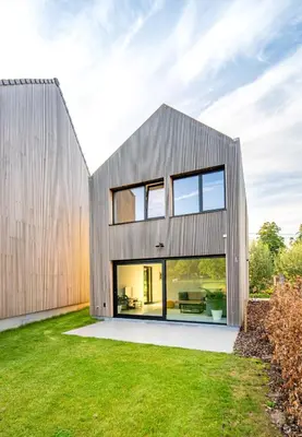 a modern house with large windows and a lawn at VELPE 55 in Bierbeek