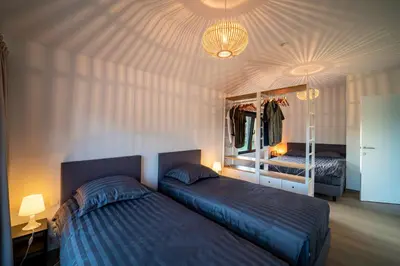 a bedroom with two beds and a chandelier at VELPE 55 in Bierbeek