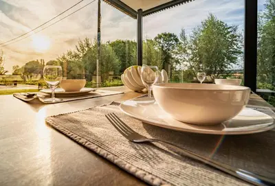 a table with a bowl and plates and wine glasses at VELPE 55 in Bierbeek
