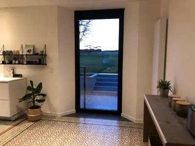 a living room with a door leading to a balcony at ma-tinée in Beauvechain