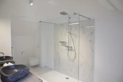 a bathroom with a glass shower with a sink at ma-tinée in Beauvechain
