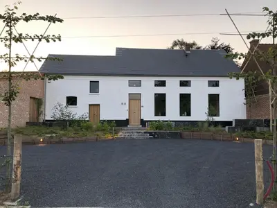 a white building with a black roof at ma-tinée in Beauvechain