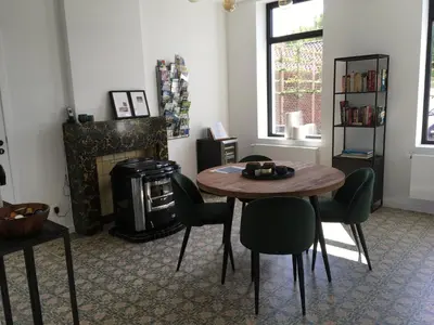 a living room with a table and chairs and a fireplace at ma-tinée in Beauvechain