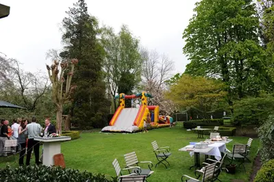 a group of people in a yard with a playground at Hotel Geerts in Westerlo