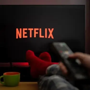 a person holding a remote control in front of a netflix sign at Brussels appartments luxury in Brussels