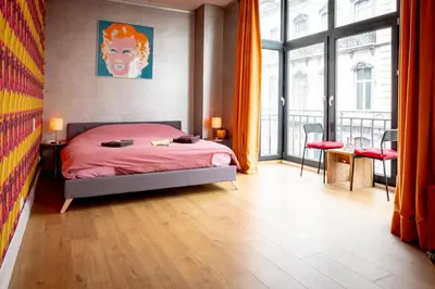 a bedroom with a bed and a large window at Quartier Leonard in Ghent