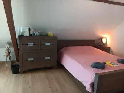 a bedroom with a bed and a dresser at Quartier Leonard in Ghent