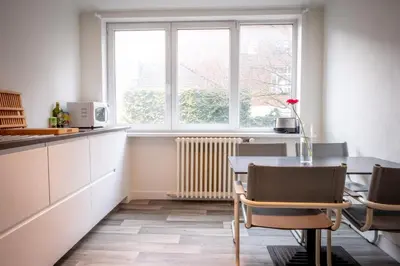 a kitchen with a table and chairs and a window at Quartier Leonard in Ghent