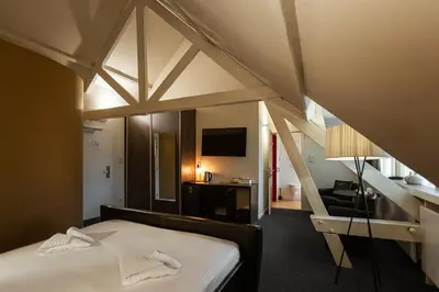 a room with a bed and a desk in a room at Hotel Orion in Ghent