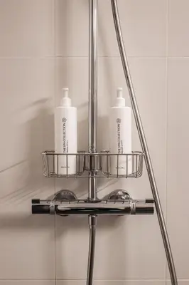 a metal shelf with two soap bottles on it in a bathroom at Hotel Orion in Ghent