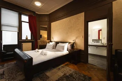 a bedroom with a bed with white sheets and pillows at Hotel Orion in Ghent