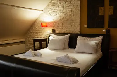 a bed with white sheets and pillows in a room at Hotel Orion in Ghent