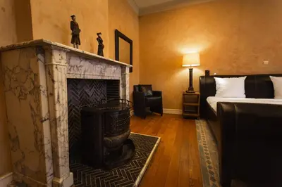 a room with a fireplace with a bed and a couch at Hotel Orion in Ghent
