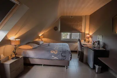 a bedroom with a bed and a desk and a desk at B&B Welcome Home in Laakdal