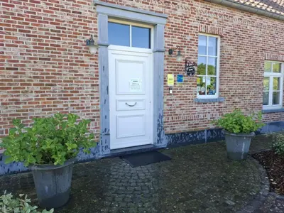 a white door on a brick building with two potted plants at B&B Welcome Home in Laakdal