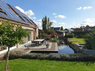 a garden with a table and a pond at B&B Welcome Home in Laakdal
