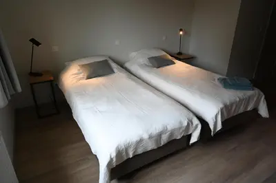two beds in a room with white sheets at B&B Dujardin in Dilbeek