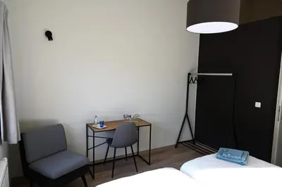a room with a desk and a chair and a bed at B&B Dujardin in Dilbeek