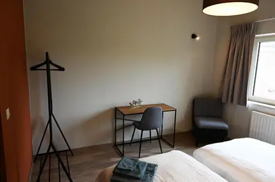 a room with a desk and a table and a chair at B&B Dujardin in Dilbeek