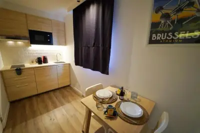a small room with a table and a kitchen at Arku apartments Brussels Airport in Zaventem