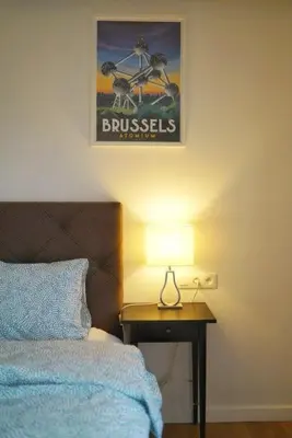 a bedroom with a bed and a table with a lamp at Arku apartments Brussels Airport in Zaventem