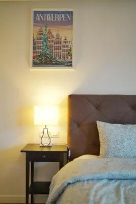 a bedroom with a bed and a table with a lamp at Arku apartments Brussels Airport in Zaventem