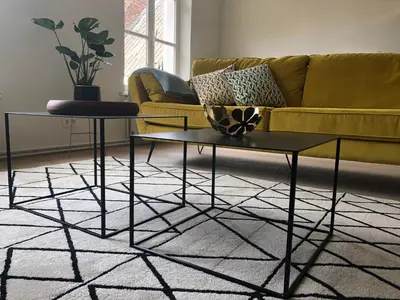 a living room with a couch and two tables at Bed & Boon in Ghent