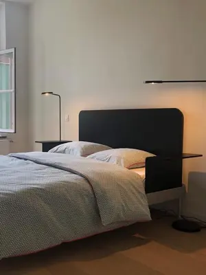 a bedroom with a bed with a table and two lamps at Bed & Boon in Ghent