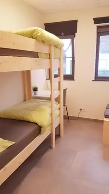 a bedroom with two bunk beds in a room at Vakantiewoning De Schuur Tienen in Tienen
