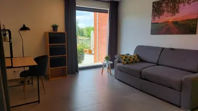 a living room with a couch and a window at Vakantiewoning De Schuur Tienen in Tienen