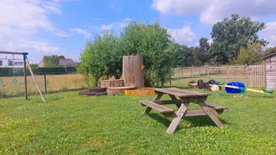 a picnic table in a yard with a playground at Vakantiewoning De Schuur Tienen in Tienen