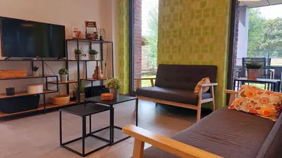 a living room with a tv and a couch and a chair at Vakantiewoning De Schuur Tienen in Tienen