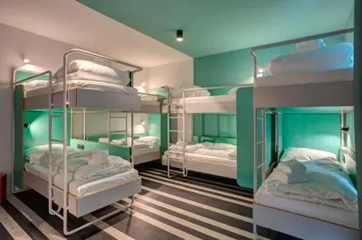 a room with four bunk beds with blue walls at MEININGER Hotel Bruxelles Gare du Midi in Brussels