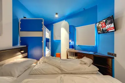 a blue room with two beds in it at MEININGER Hotel Bruxelles Gare du Midi in Brussels