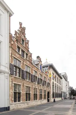 a large brick building with flags on a street at Theaterstudio 1 Antwerp in Antwerp