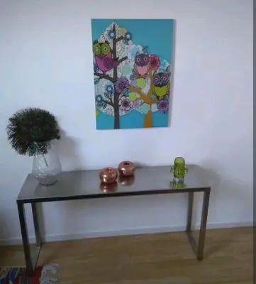 a table in a room with a painting on the wall at Land Scape guesthouse in Eeklo