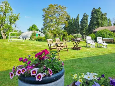 a garden with a table and chairs and flowers at COSY B&B 2B in Overijse