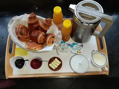a table with a tray of pastries and orange juice at COSY B&B 2B in Overijse