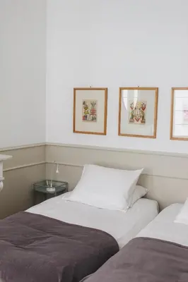 two beds in a room with pictures on the wall at Holiday Home Jules in Antwerp