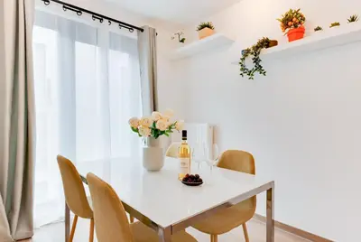 a white dining room with a white table and chairs at Royal Arts-Loi Studio in Brussels