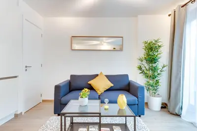 a living room with a blue couch and a coffee table at Royal Arts-Loi Studio in Brussels