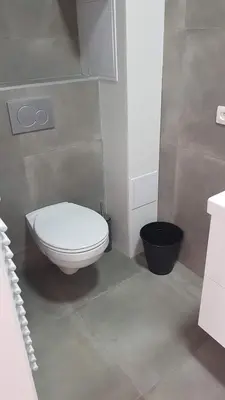 a bathroom with a white toilet and a black bucket at Attractive modern apartment in Brussels