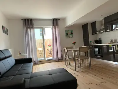a living room with a couch and a table with chairs at Attractive modern apartment in Brussels