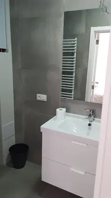 a bathroom with a white sink and a mirror at Attractive modern apartment in Brussels