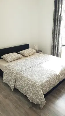 a bedroom with a bed with a white comforter at Modern Apartment Second Floor in Brussels