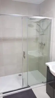 a shower with a glass door next to a sink at Modern Apartment First Floor in Brussels